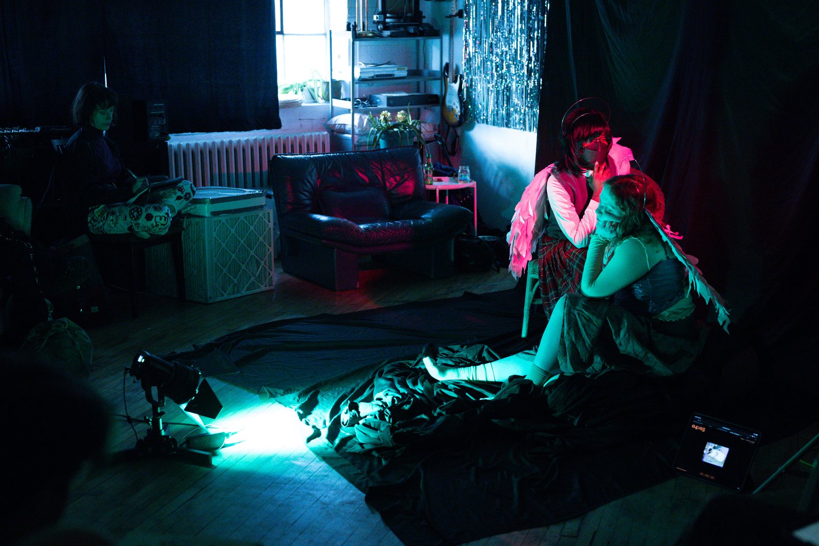 Lost Angels, angel seated on the floor in deep teal light