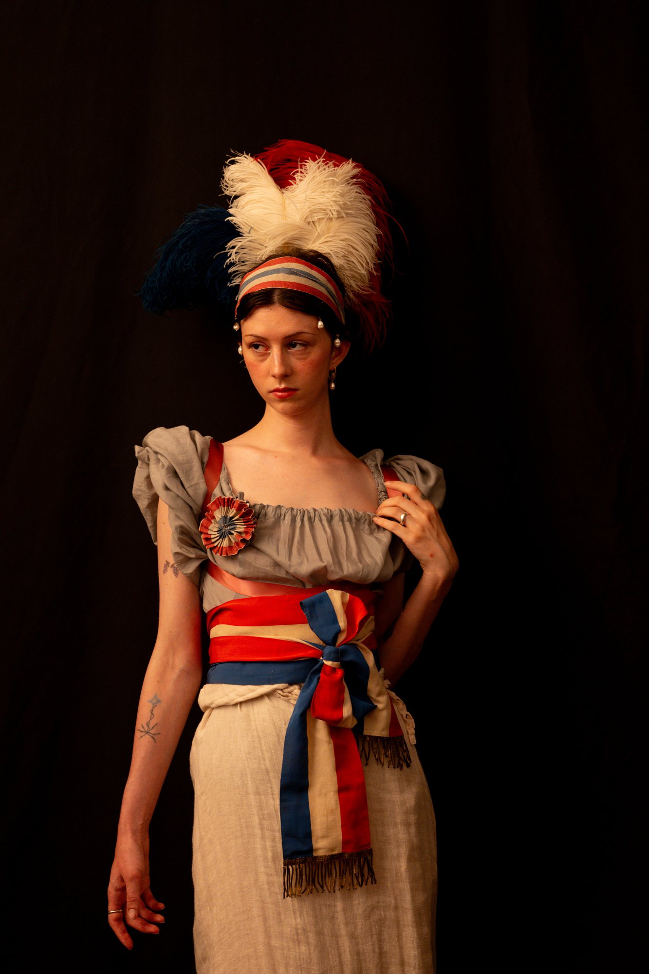 French Revolution photoshoot, model in a tricolour sash and empire dress