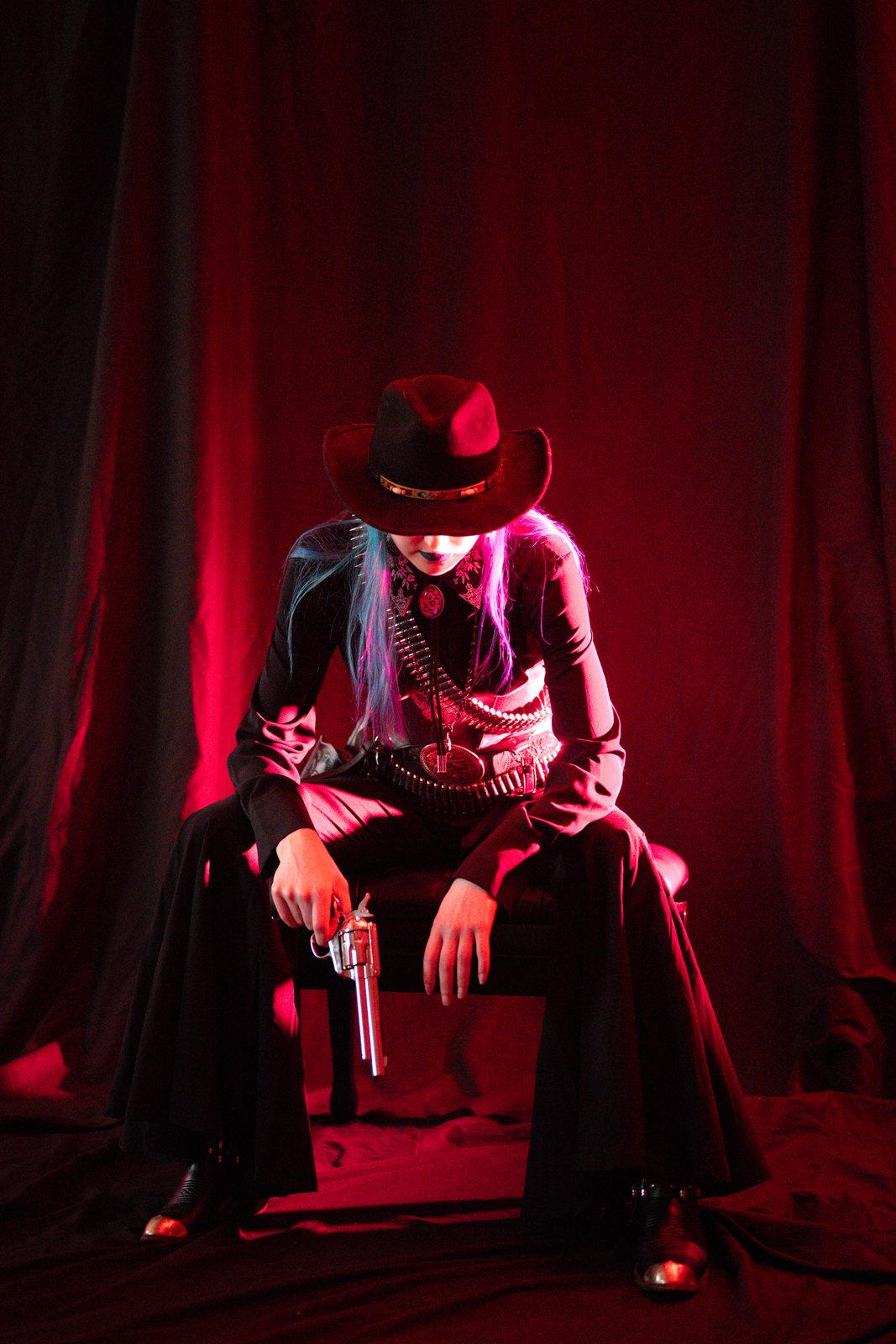 Gothic Country, model seated with a revolver in red light