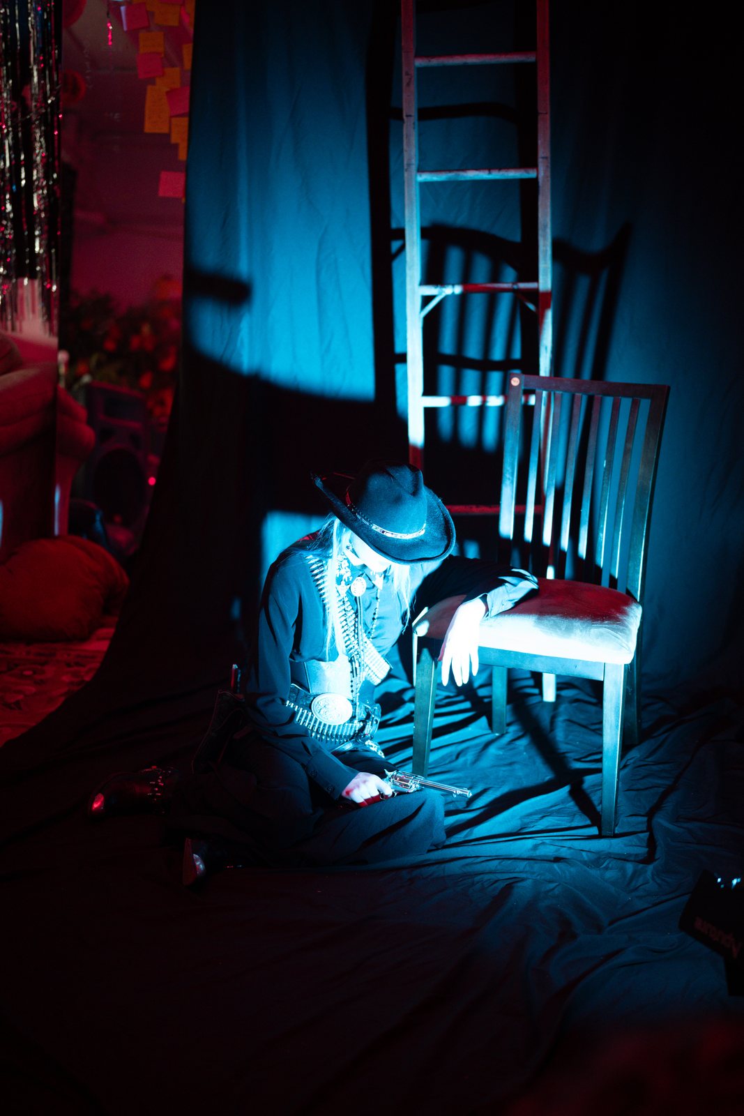 Gothic Country, model seated by a chair in blue light