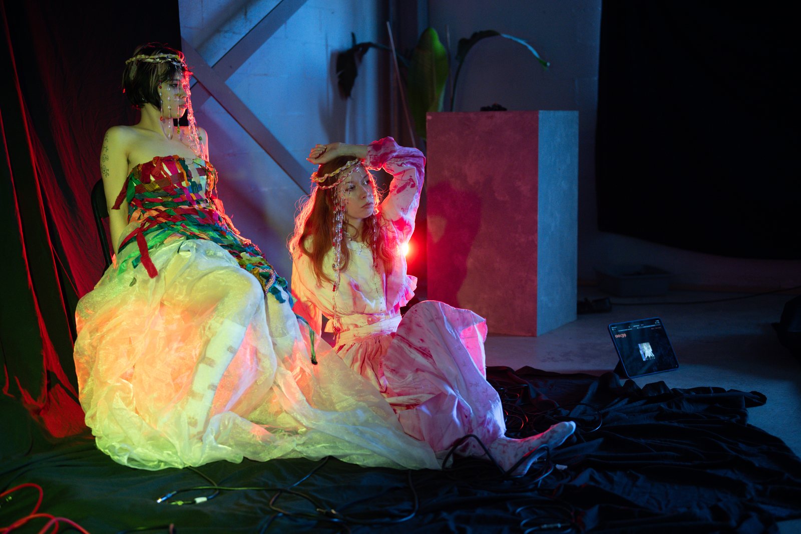 Post Apocalypse, two models in glowing gowns under warm backlight