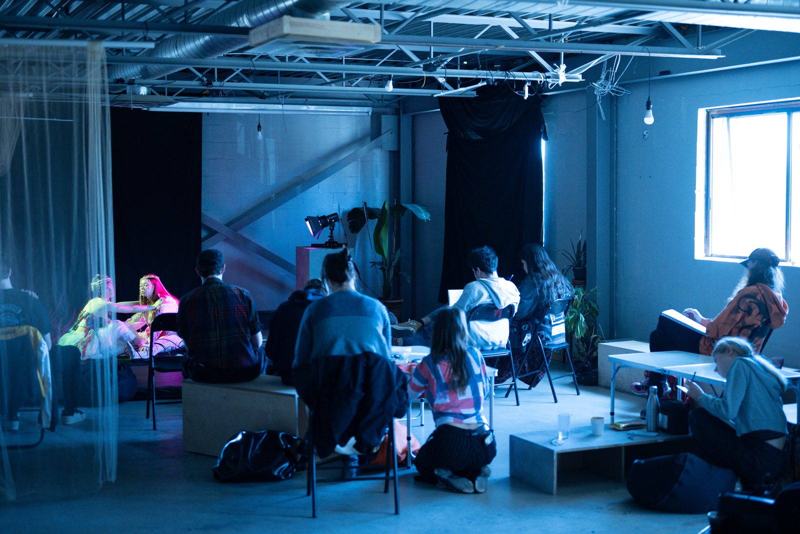 Post Apocalypse, artists drawing at tables in the loft